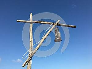 Old rusty kerosene lamp with a white wire on a street wooden post crane photo