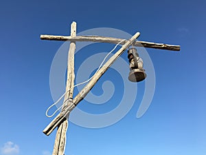 Old rusty kerosene lamp with a white wire on a street wooden post crane photo