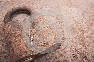 Old rusty key and lock. Vintage door padlock with key. Antique key on weathered background. Security and safety concept.