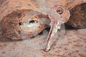 Old rusty key and lock. Vintage door padlock with key. Antique key on weathered background. Security and safety concept.