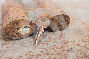 Old rusty key and lock. Vintage door padlock with key. Antique key on weathered background. Security and safety concept.