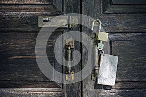 Old rusty and key locks on wooden door