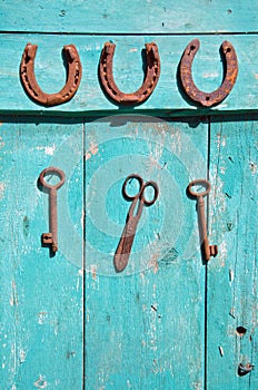 Old rusty key and luck symbol horseshoe on wooden farm wall