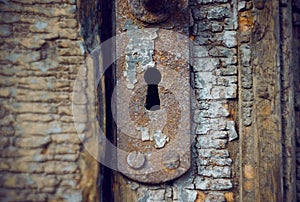 Old rusty keyhole in the old wooden door