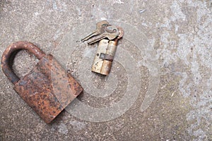 Old rusty keys, lock and antique padlock. Vintage door padlock with key. Antique key on weathered background. Security and safety.