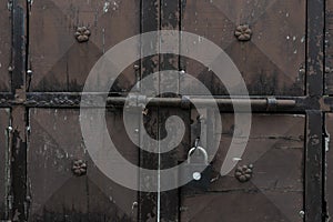 Old and rusty latch and handle on metal door. old castle, house, basement or room door