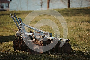 Old rusty lawnmower working in a field