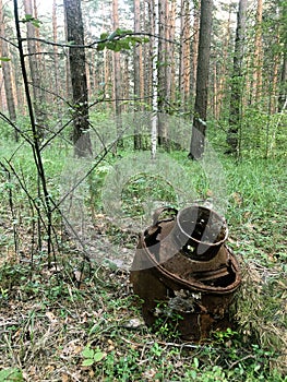 An old rusty leaky barrel in the grass