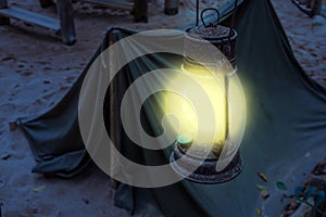 Old rusty Lighted lantern shining bright light during night, Miner camp, Survival hike in nature by night