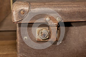 A rusty lock on an old brown leather suitcase