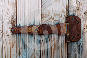 Old rusty lock hanging on the gray wooden door.