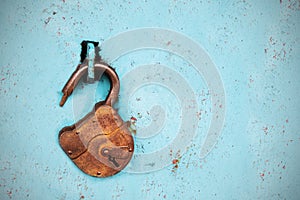 Old rusty lock without a key on a blue background