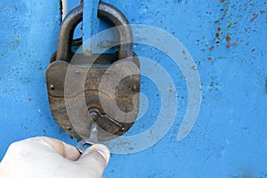 Old rusty lock with a key on a blue background