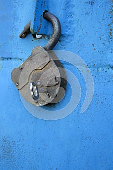 Old rusty lock with a key on a blue background