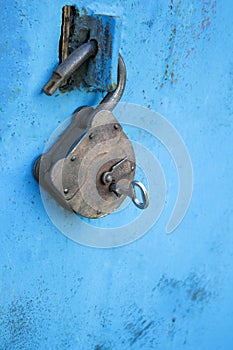 Old rusty lock with a key on a blue background