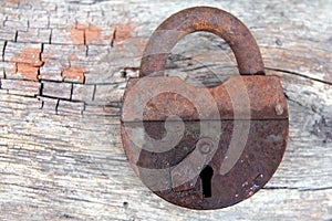 Old rusty lock on a wooden background