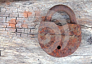 Old rusty lock on a wooden background