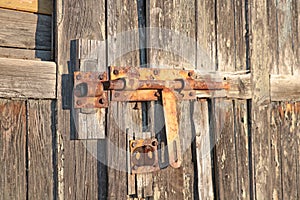 Old rusty lock on the wooden door, background.