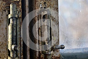 Old rusty locks and hinges on the window