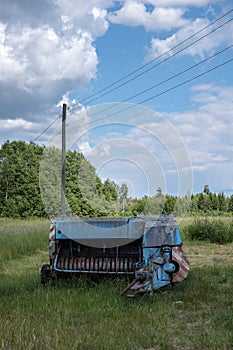 old rusty machinery in the green meadow