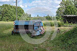 old rusty machinery in the green meadow