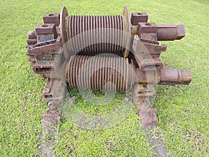  old rusty machinery wheel in green field background. Martinique island. French West Indies