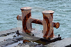 Old rusty metal bollard pier - device for yacht mooring