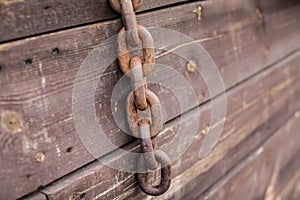 Old rusty metal chains on the wooden background in selective focus