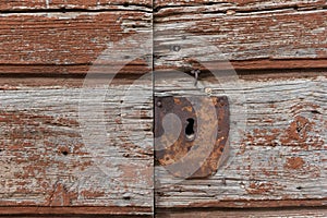 Old rusty metal keyhole on old brown wooden door. Rusty keyhole