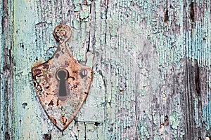 Old rusty metal lock and keyhole on a old turquoise wooden door