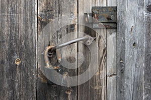 old rusty metal padlock on an old wooden door