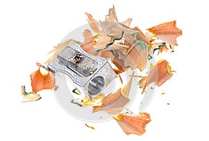 Old rusty metal pencil sharpener and different colour shavings.