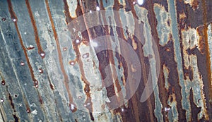 Old rusty metal sheet with dots of sun light through the holes