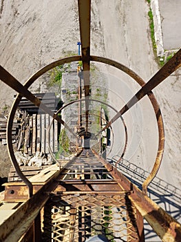 Old rusty metal structures. Old gantry crane. Descent down, passage.