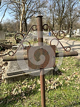 Old rusty metal tombstone in the public cemetery