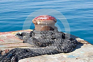 Old rusty mooring bollard on pier