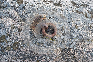 Old and rusty mooring ring for ships fixing.