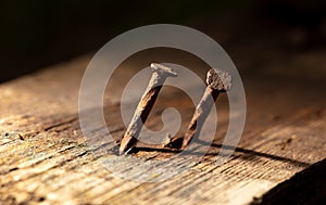 An old rusty nail driven into a wooden board.