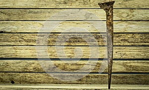 Old rusty nail on wooden background