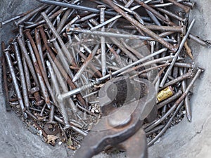 Old rusty nails lie in an iron bowl close-up