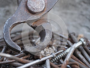 Old rusty nails lie in an iron bowl close-up