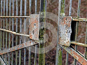 Old rusty open gate with broken lock, ajar