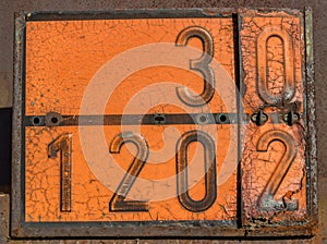 Old and rusty orange plate with hazard identification number