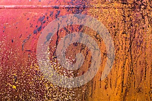 Old rusty orange red iron metal wall with color splashes
