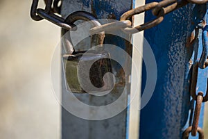 Old rusty padlock and chain on metal door. Old locked gate with chains