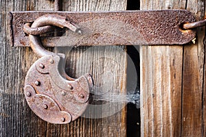 Old rusty padlock and spiderweb on wooden background, old mystery of the past