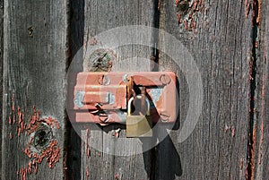 Old rusty padlock on wooden door of old shed