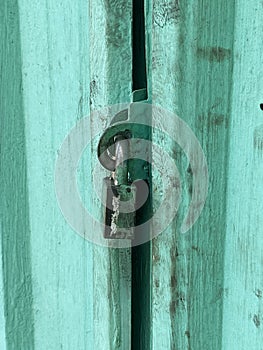 Old rusty padlock on a wooden door