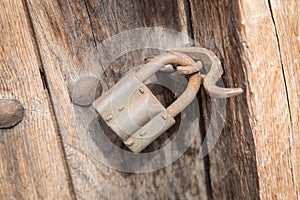 Old rusty padlock on a wooden door