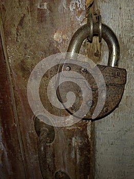 Old rusty padlock on an old wooden door